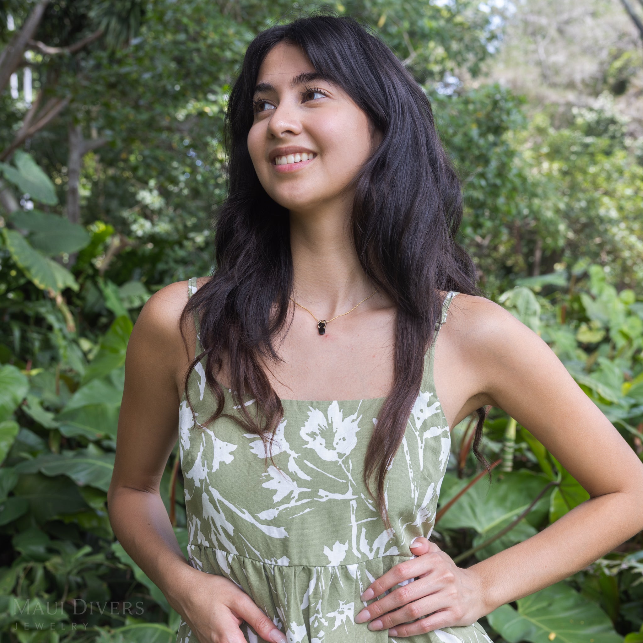 Woman in garden wearing Hawaiian Black Coral Slipper Pendant with 14k Yellow Gold Straps