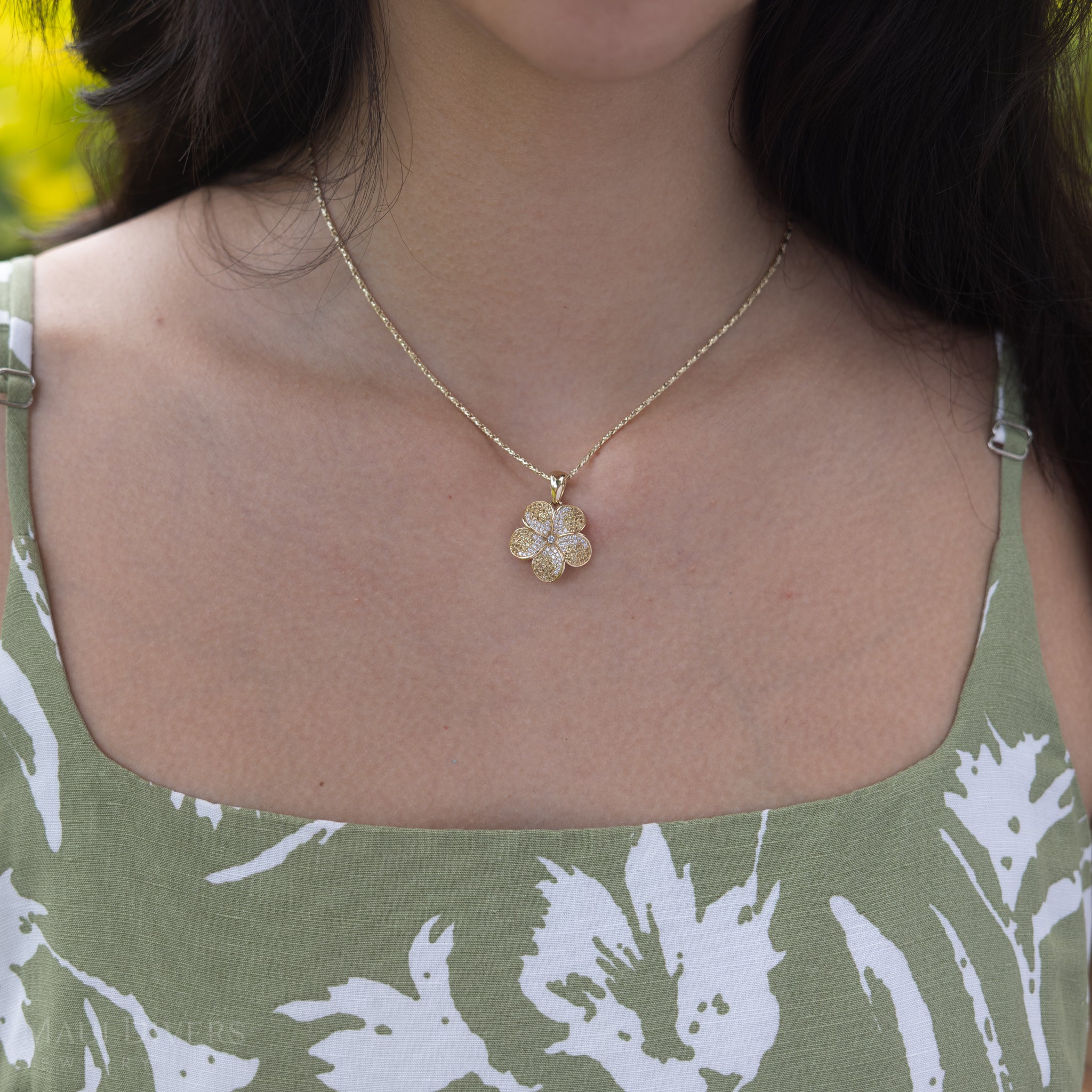Close up of a woman's chest wearing a Plumeria Yellow Sapphire Pendant in Gold with Diamonds
