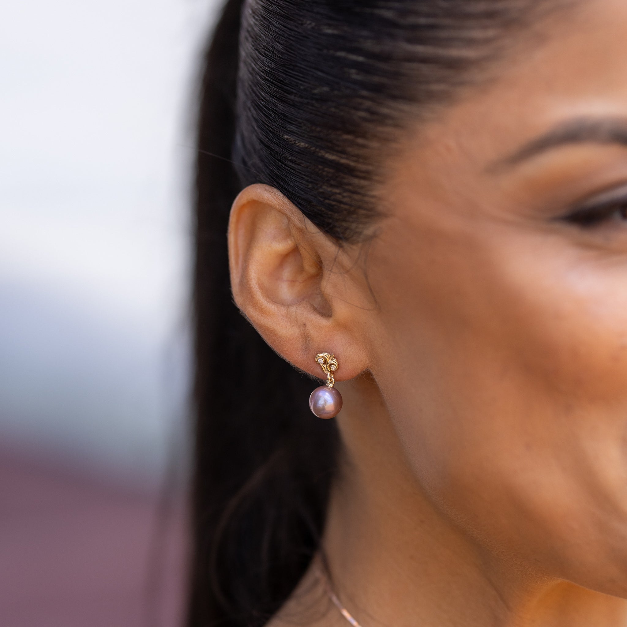 Close-up of a woman wearing a Living Heirloom freshwater pearl earring.