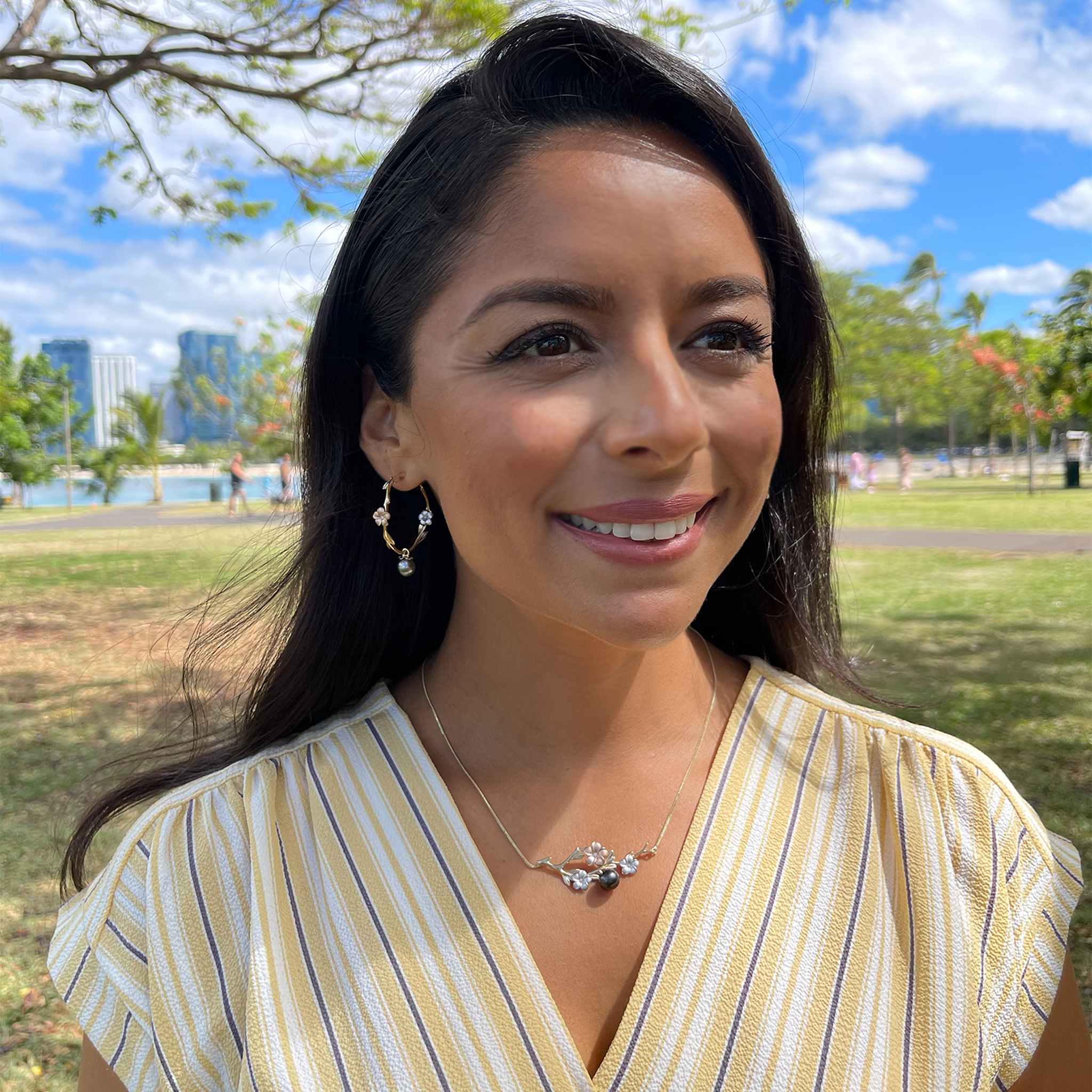 A woman wearing Pearls in Bloom Plumeria Tahitian Black Pearl Earrings in Tri Color Gold with Diamonds - 33mm - Maui Divers Jewelry