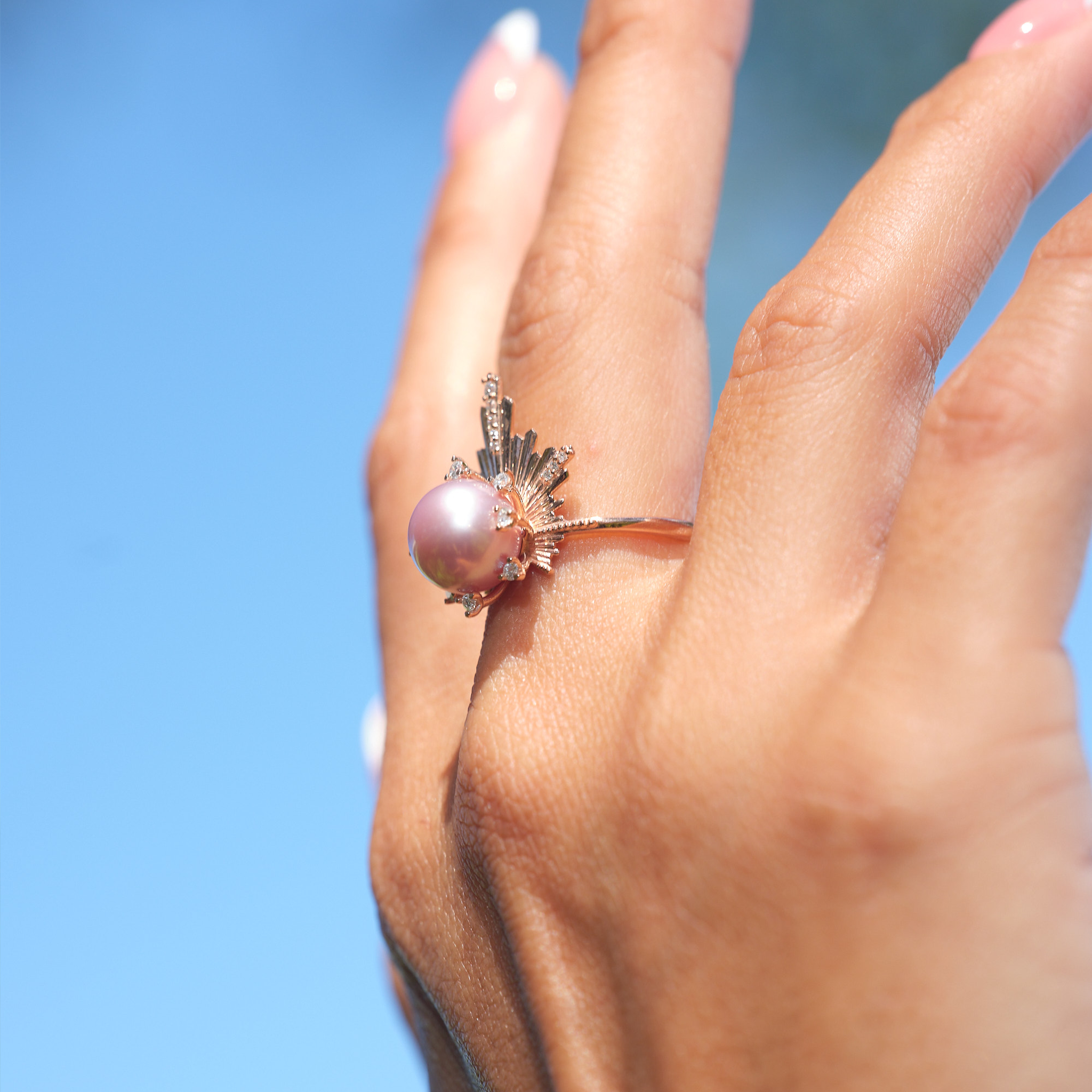 A woman's hand wearing a E Hoʻāla Lavender Freshwater Pearl Ring in Rose Gold with Diamonds - 21mm - Maui Divers Jewelry