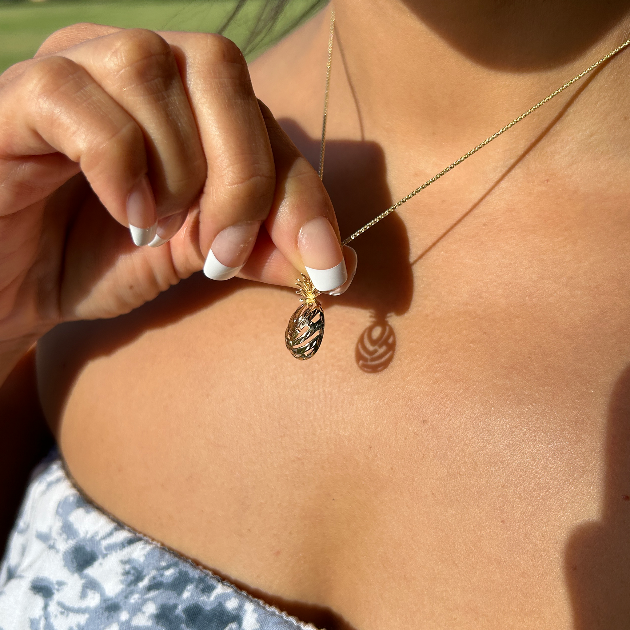 A woman wearing a Aloha Pineapple Pendant in Gold-Maui Divers Jewelry