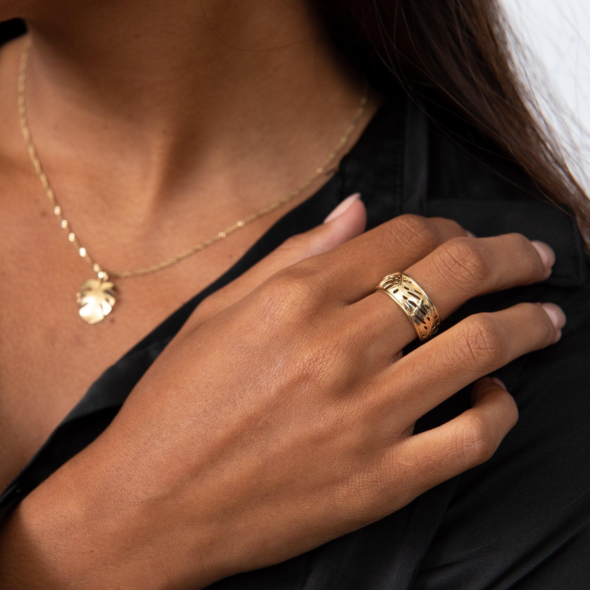 Close up of a 8mm Monstera Ring in Gold on a woman's hand in studio