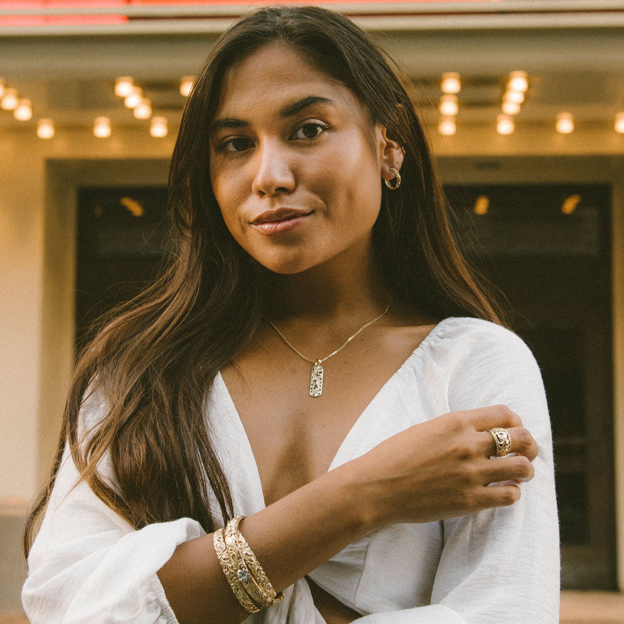 A woman wearing Hawaiian Heirloom Maile Scroll Earrings in Gold - Small-Maui Divers Jewelry