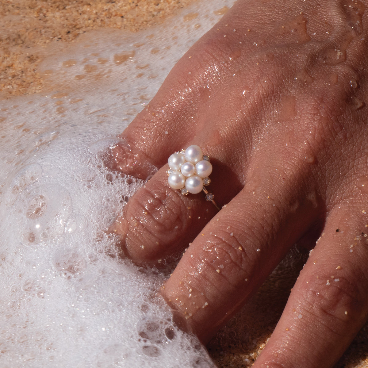 A woman's hand in the water wearing a Tiny Bubbles White Freshwater Pearl Ring in Gold with Diamonds - Maui Divers Jewelry