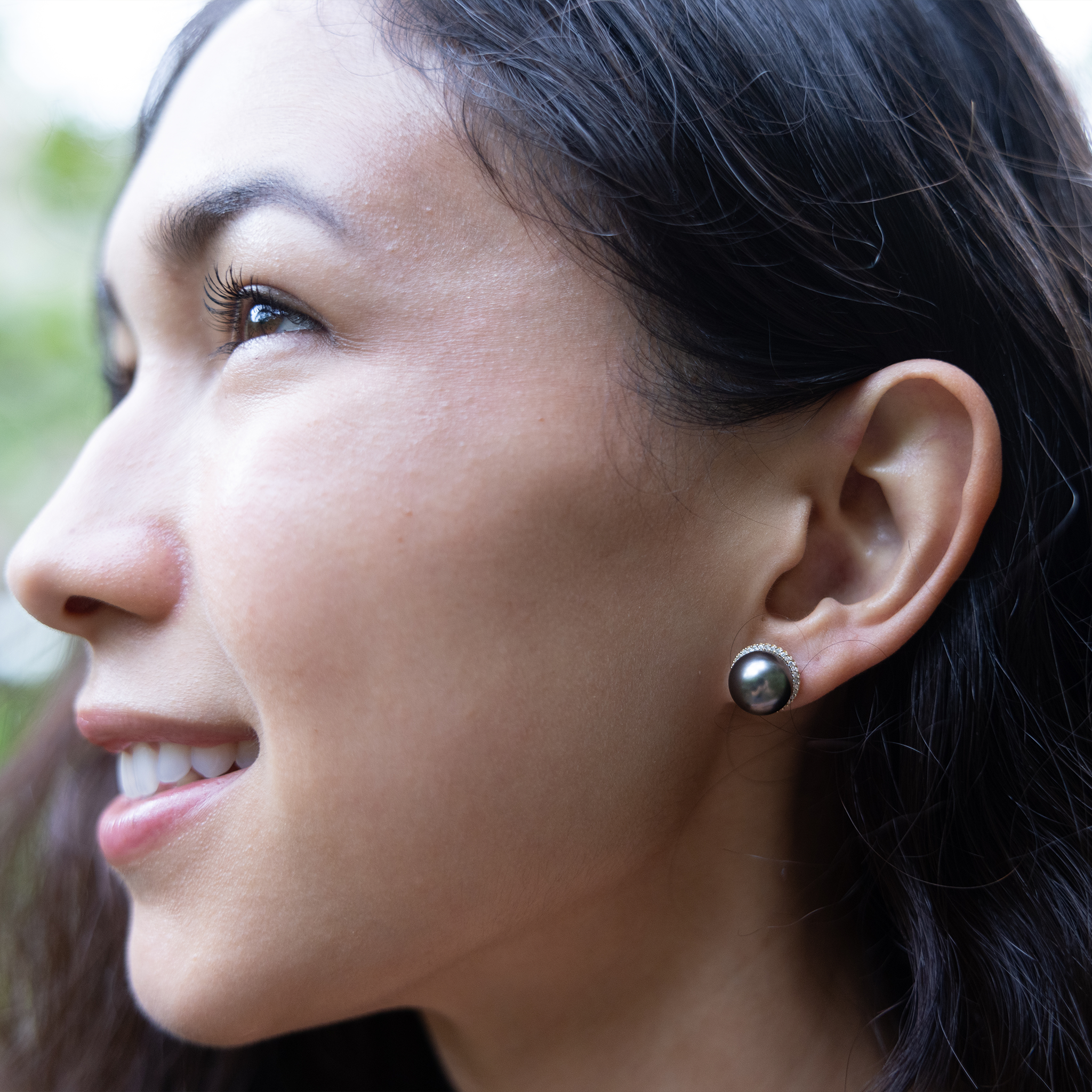 Woman wearing a diamond halo Tahitian black pearl earring