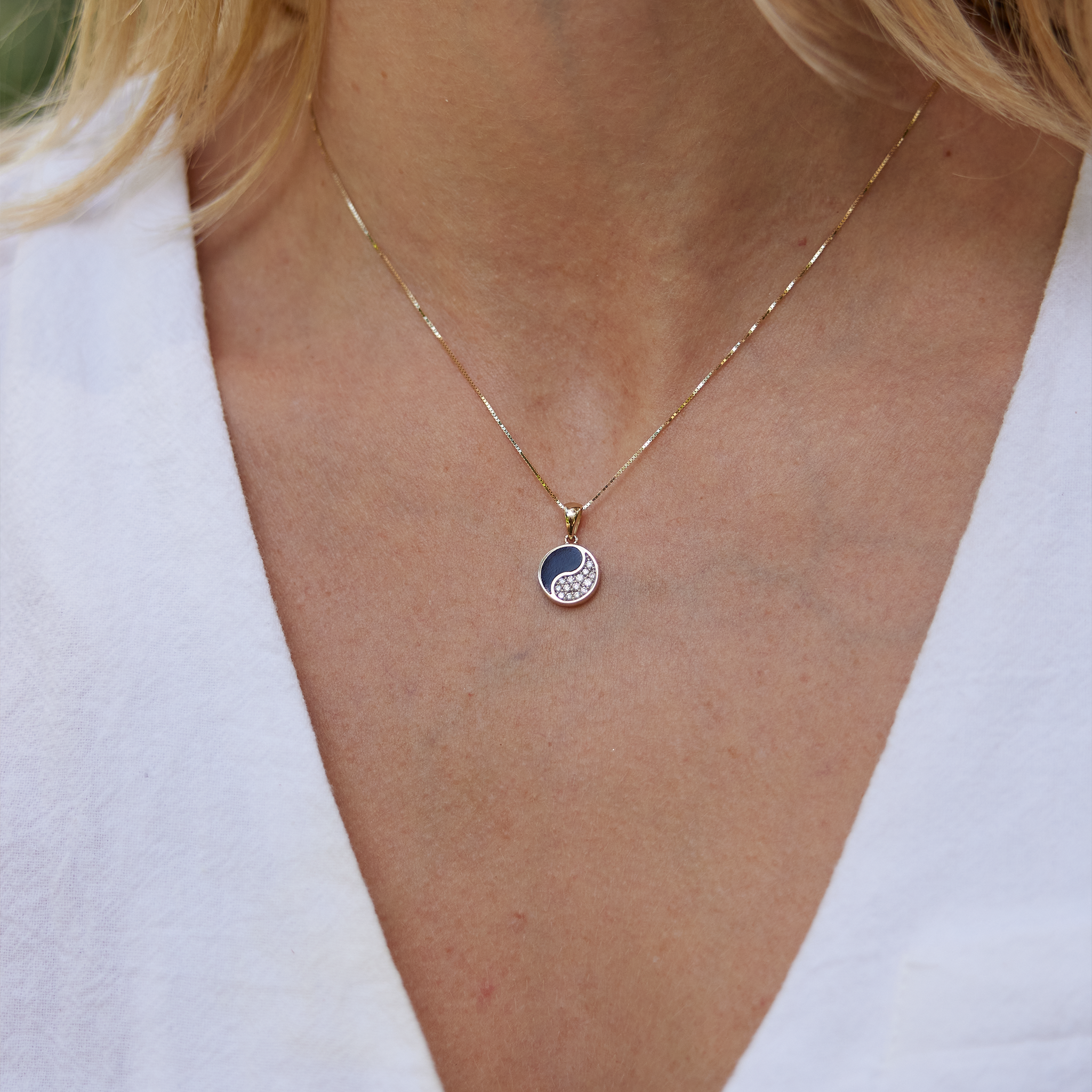 クローズアップ:陰陽黒珊瑚ペンダント ダイヤモンド・ゴールド 10mm 女性のネックラインに