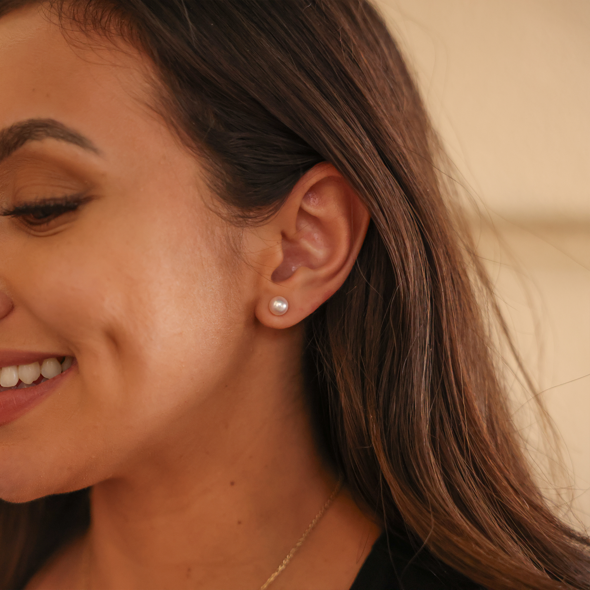 Close_up_of_smiling_woman_s_left_ear_with_an_akoya_white_pearl_earring