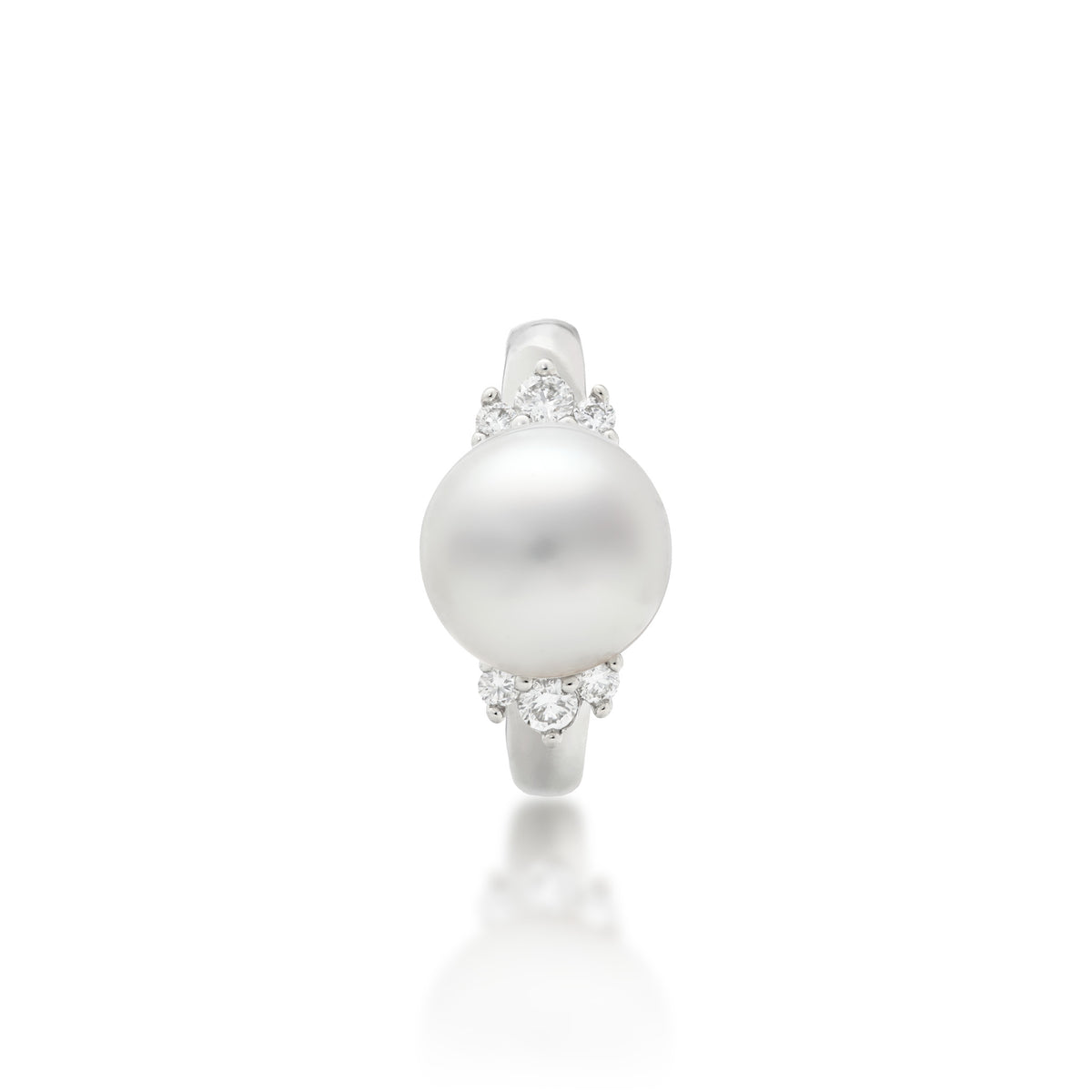 Top view of a 14k white gold ring featuring a large, lustrous South Sea White pearl as the center stone, accented by three diamonds on either side of the band, set against a clean white background with a soft reflection below.