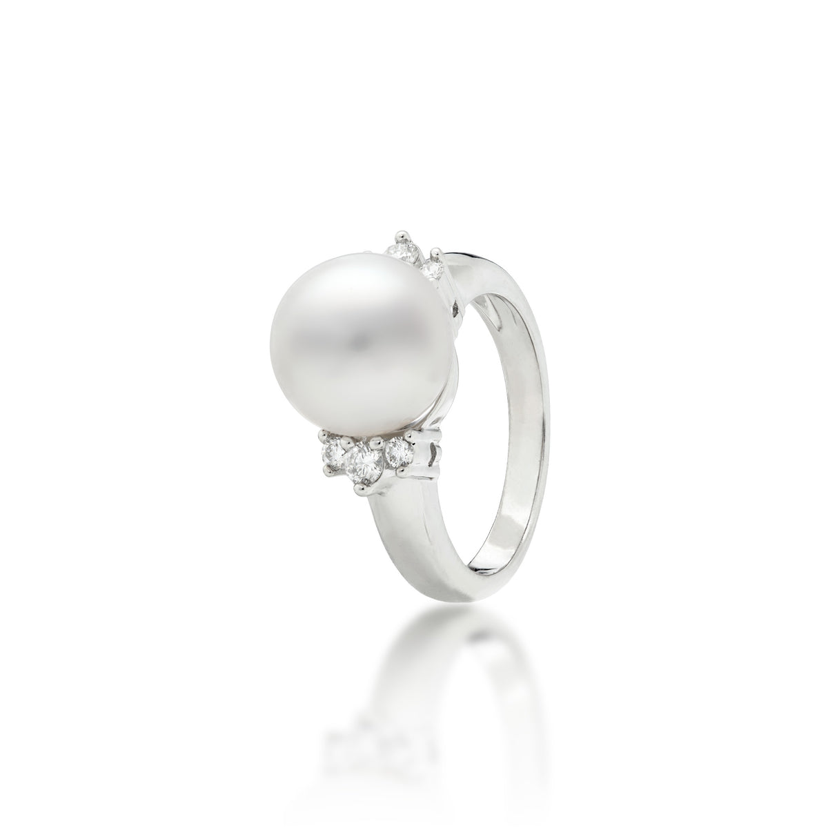 A 14k white gold ring featuring a large, lustrous South Sea White pearl as the center stone, accented by three diamonds on either side of the band, set against a clean white background with a soft reflection below.