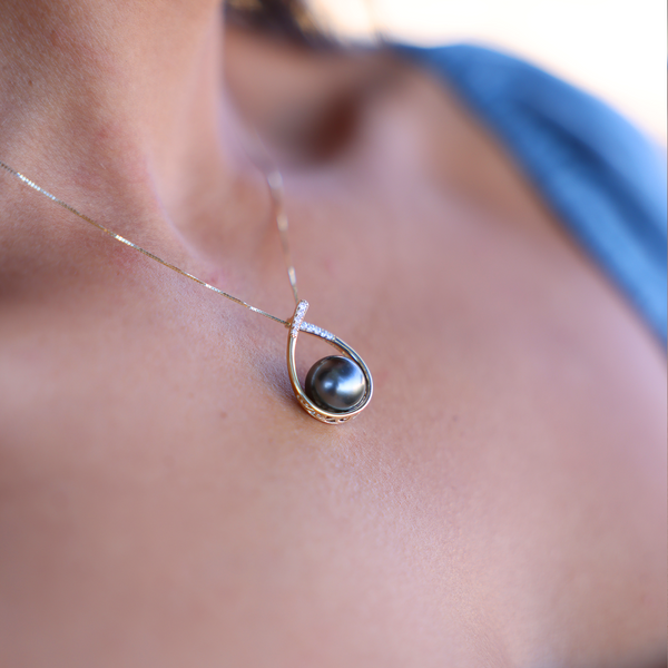 A woman's chest with a Teardrop Tahitian Black Pearl Pendant in Gold with Diamonds - 10-11mm - Maui Divers Jewelry