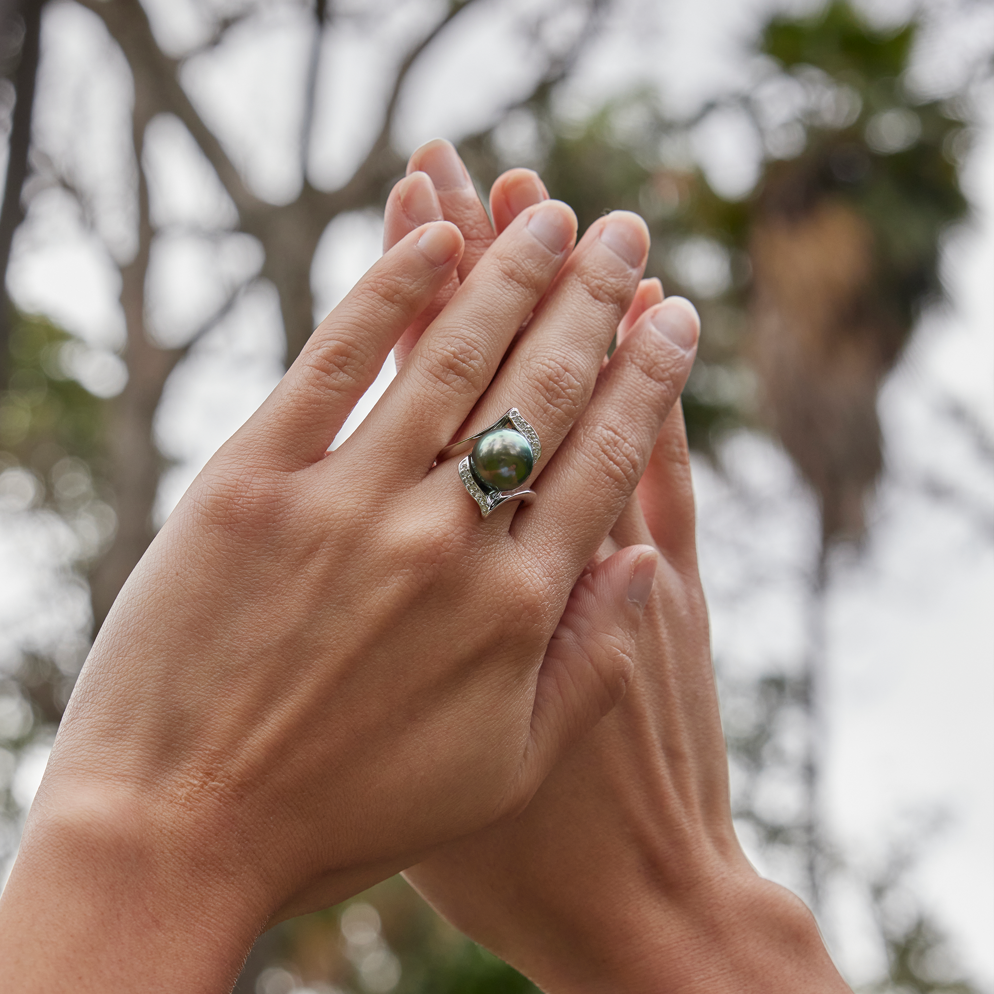 Hands together with Tahitian Black Pearl Ring in White Gold with Diamonds