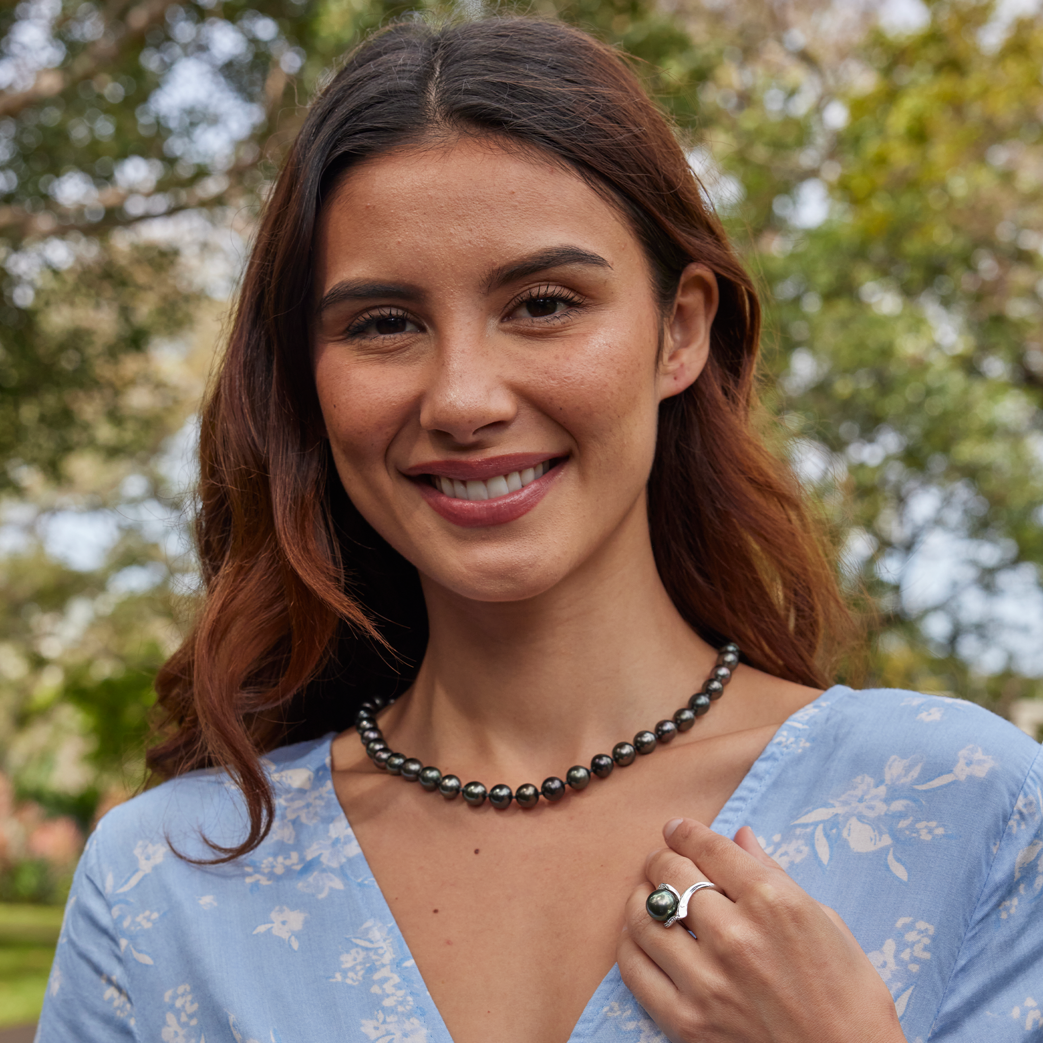 Smiling woman wearing a Tahitian black pearl strand and Tahitian Black Pearl Ring in White Gold with Diamonds 