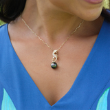 A womanʻs chest with an Ocean Dance Seahorse Tahitian Black Pearl Pendant in Gold with Diamonds - 9-10mm - Maui Divers Jewelry