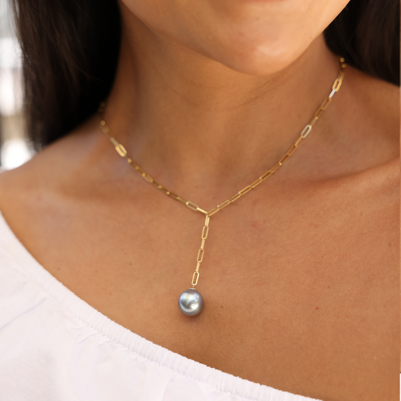 A woman's chest with a Tahitian Black Pearl Y Necklace in Gold - 12-14mm - Maui Divers Jewelry