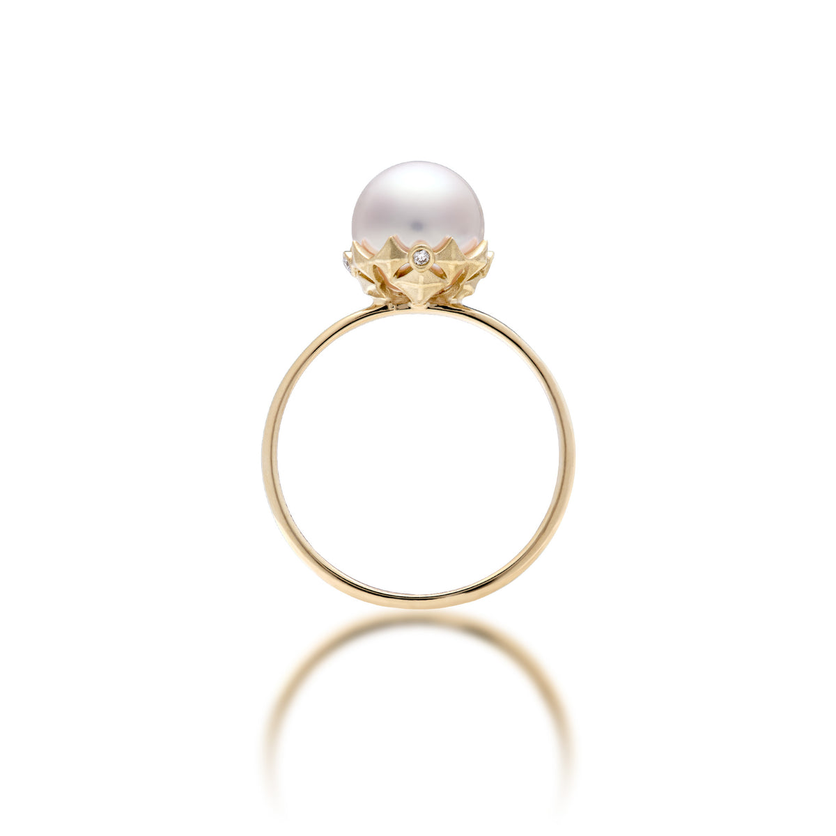 An 8mm Akoya white pearl ring in 14k yellow gold with a Hawaiian quilted star design with diamonds around the crown, shown on a white background