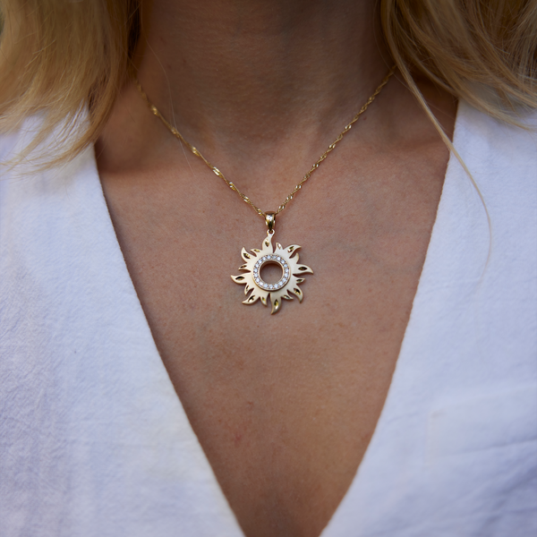 Close up of womanʻs neckline wearing Sun Pendant in Gold with Diamonds - 29mm