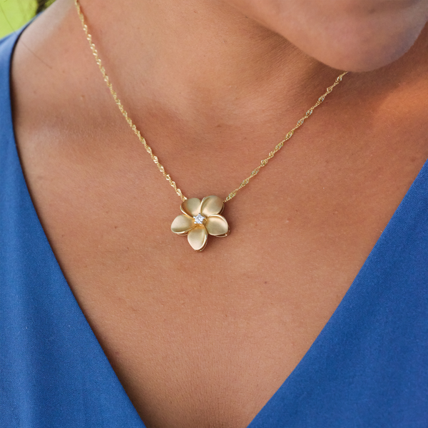 A woman wearing a Plumeria Pendant in Gold with Diamond - 20mm - Maui Divers Jewelry
