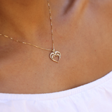 A woman's chest with a Nalu Heart Pendant in gold with Diamonds - 15mm - Maui Divers Jewelry