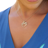 A woman wearing a Nalu Heart Pendant with Diamonds in Gold - 20mm-Maui Divers Jewelry