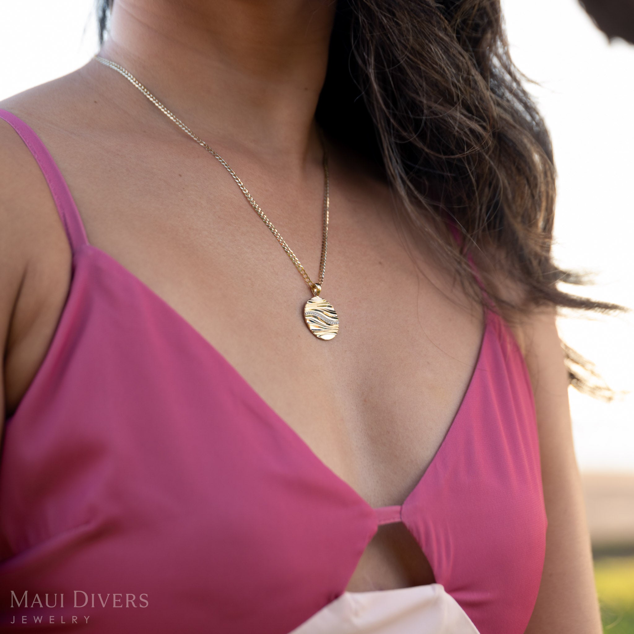 Woman wearing a pink top with the Ocean Sand Pendant on a 2.5mm curb chain