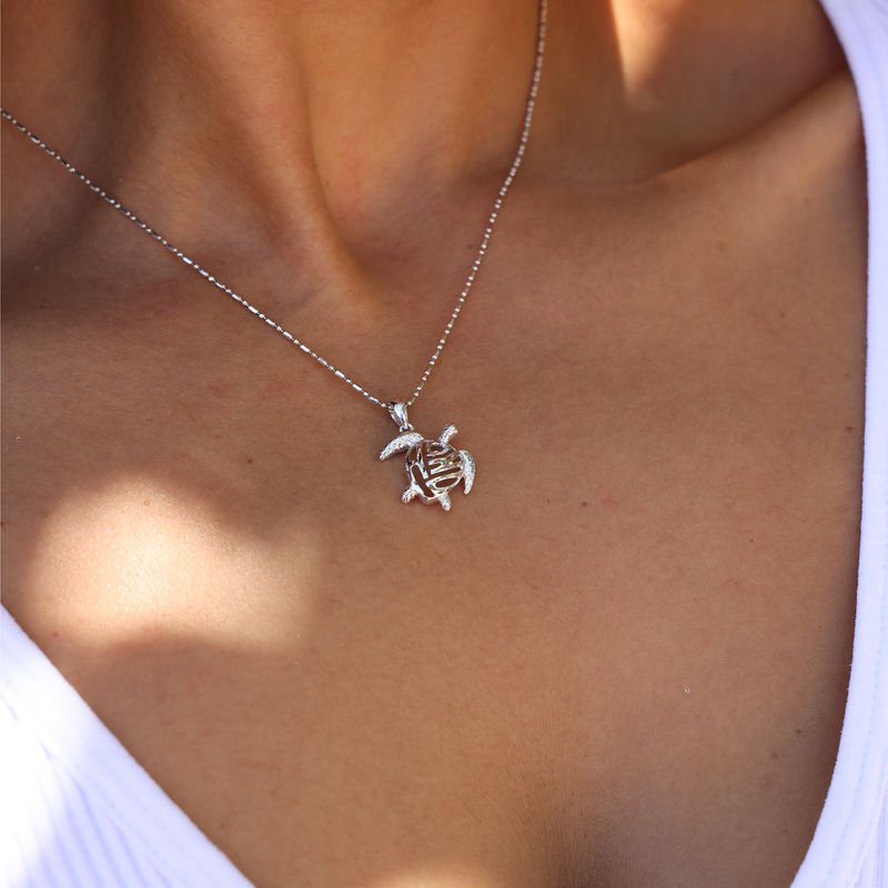 A woman wearing a Honu Pendant in White Gold - 15mm - Maui Divers Jewelry