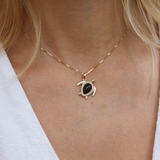 Close up of womanʻs neckline wearing Honu Black Coral Pendant in Gold with Diamonds - 18mm