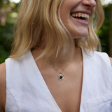 Woman with white shirt laughing and wearing Honu Black Coral Pendant in Gold with Diamonds - 18mm