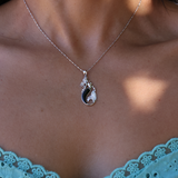 A woman's chest with a Sealife Mermaid Black Coral Pendant in White Gold with Diamonds - 30mm - Maui Divers Jewelry