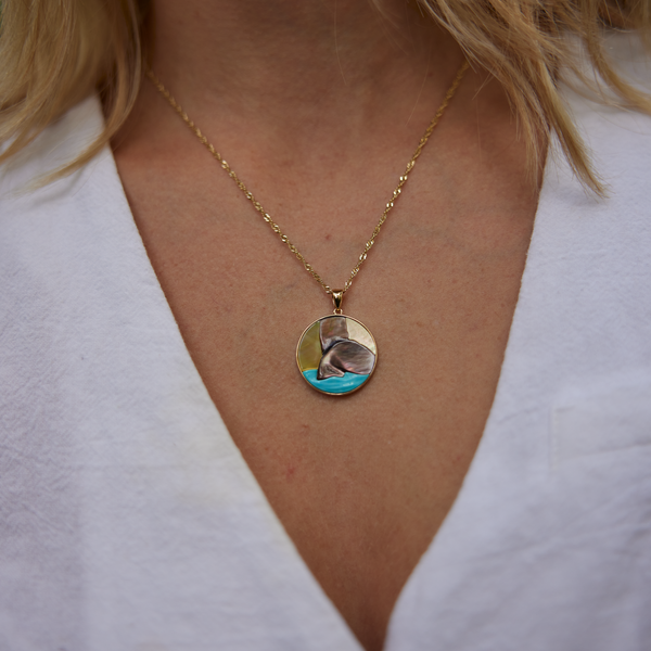 Hawaiian Moments Whale Tail Mother of Pearl & Turquoise Pendant in Gold on womanʻs neckline