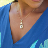 A woman's chest with a Sealife Mermaid Mother of Pearl Pendant in Gold with Diamonds - 30mm - Maui Divers Jewelry