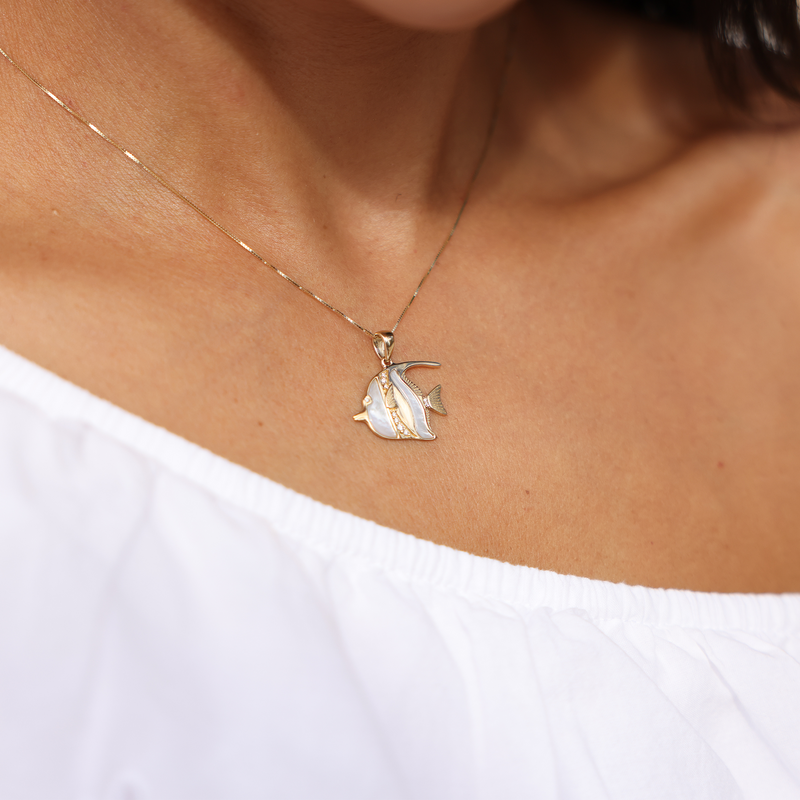A womanʻs chest with a Sealife Angelfish Mother of Pearl in Gold with Diamonds - 23mm - Maui Divers Jewelry