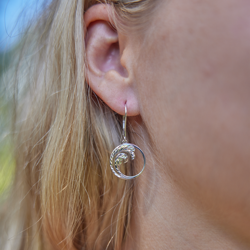 Close up of womanʻs right ear wearing Nalu Earrings in Sterling Silver - 18mm