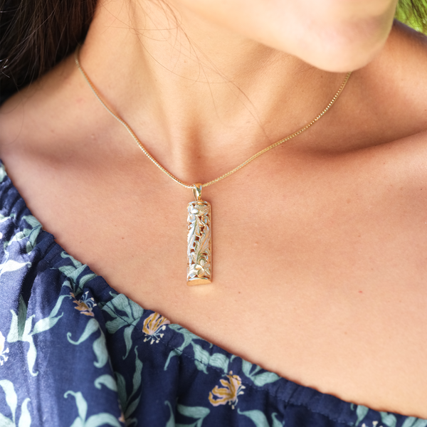 A woman's neck with a Hawaiian Heirloom Plumeria Pendant in Gold - 38mm - Maui Divers Jewelry