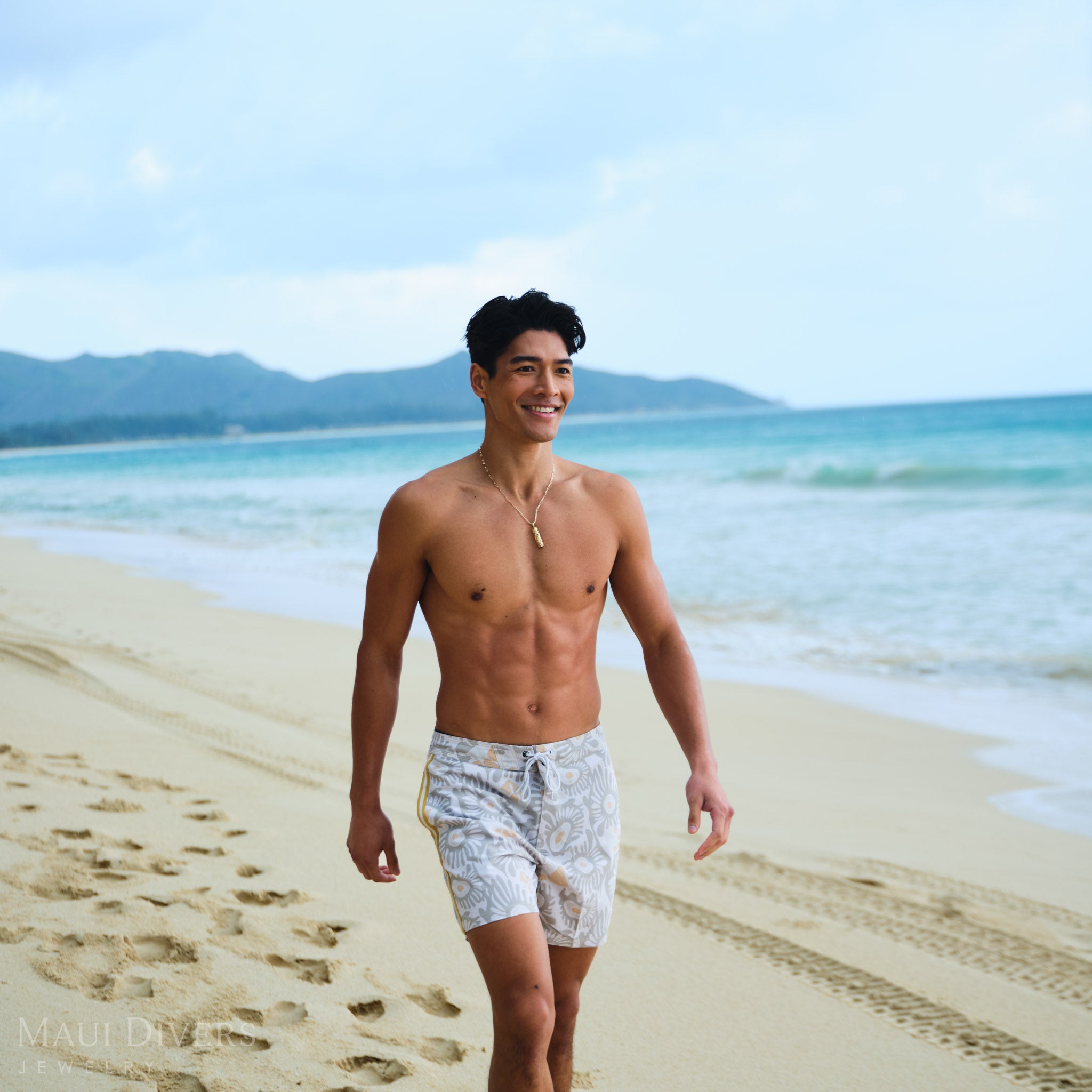 Man wearing a gold Hawaiian Heirloom Pendant on a Paperclip Chain on a beach