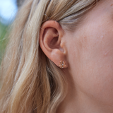 Womanʻs right ear with Hawaiian Heirloom Plumeria Earrings in Rose Gold with Diamonds