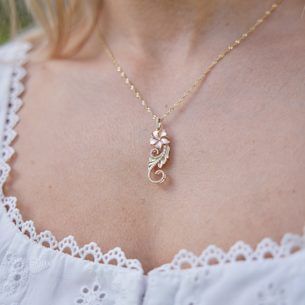 close up of womanʻs neckline wearing Hawaiian Heirloom Plumeria Pendant in Two Tone Gold with Diamonds - 30mm
