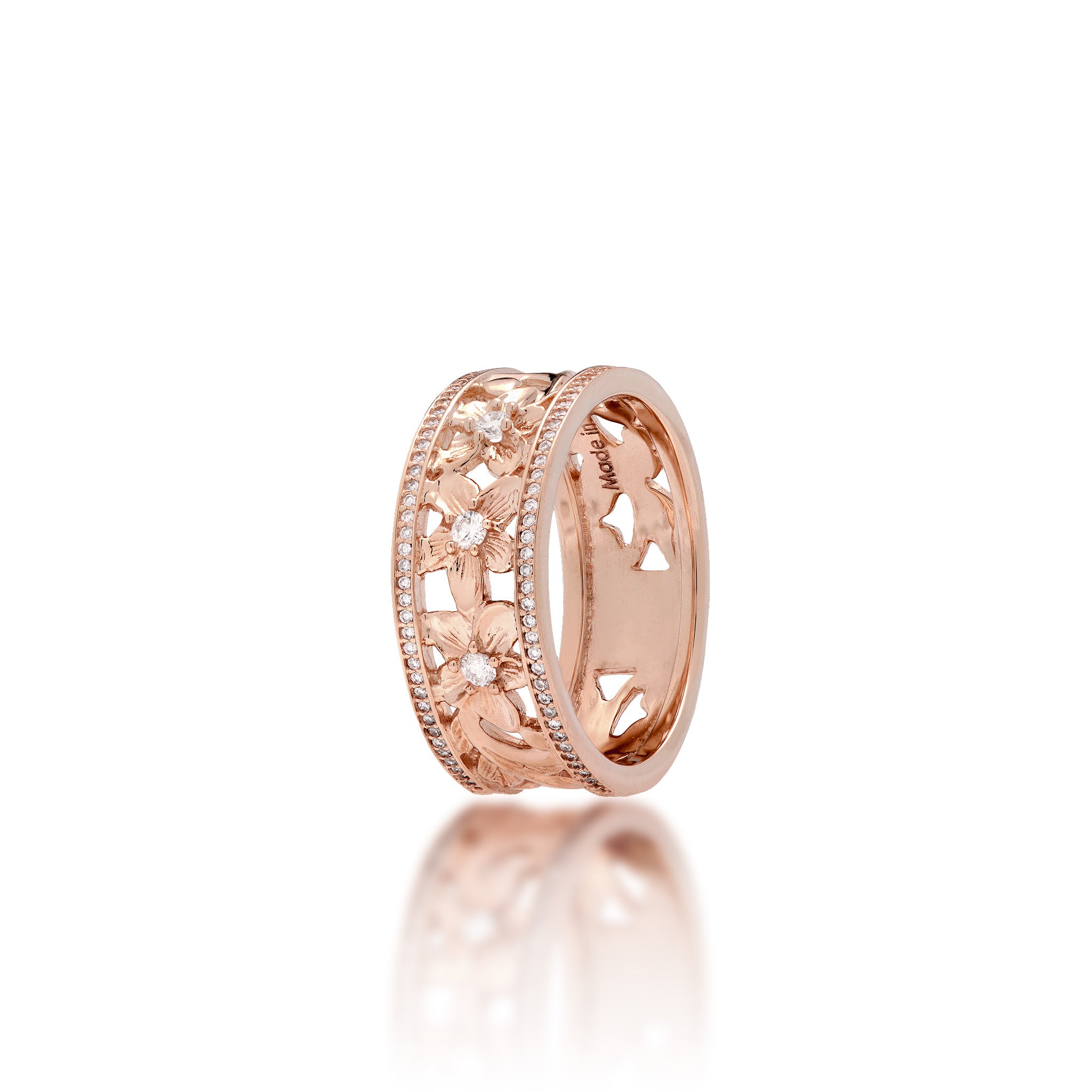 A 14k rose gold Hawaiian Heirloom ring featuring a row of small pavé-set diamonds on each side of the band and cut-out diamond-accented plumeria flowers at the center, shown on a clean white background with a soft reflection below.