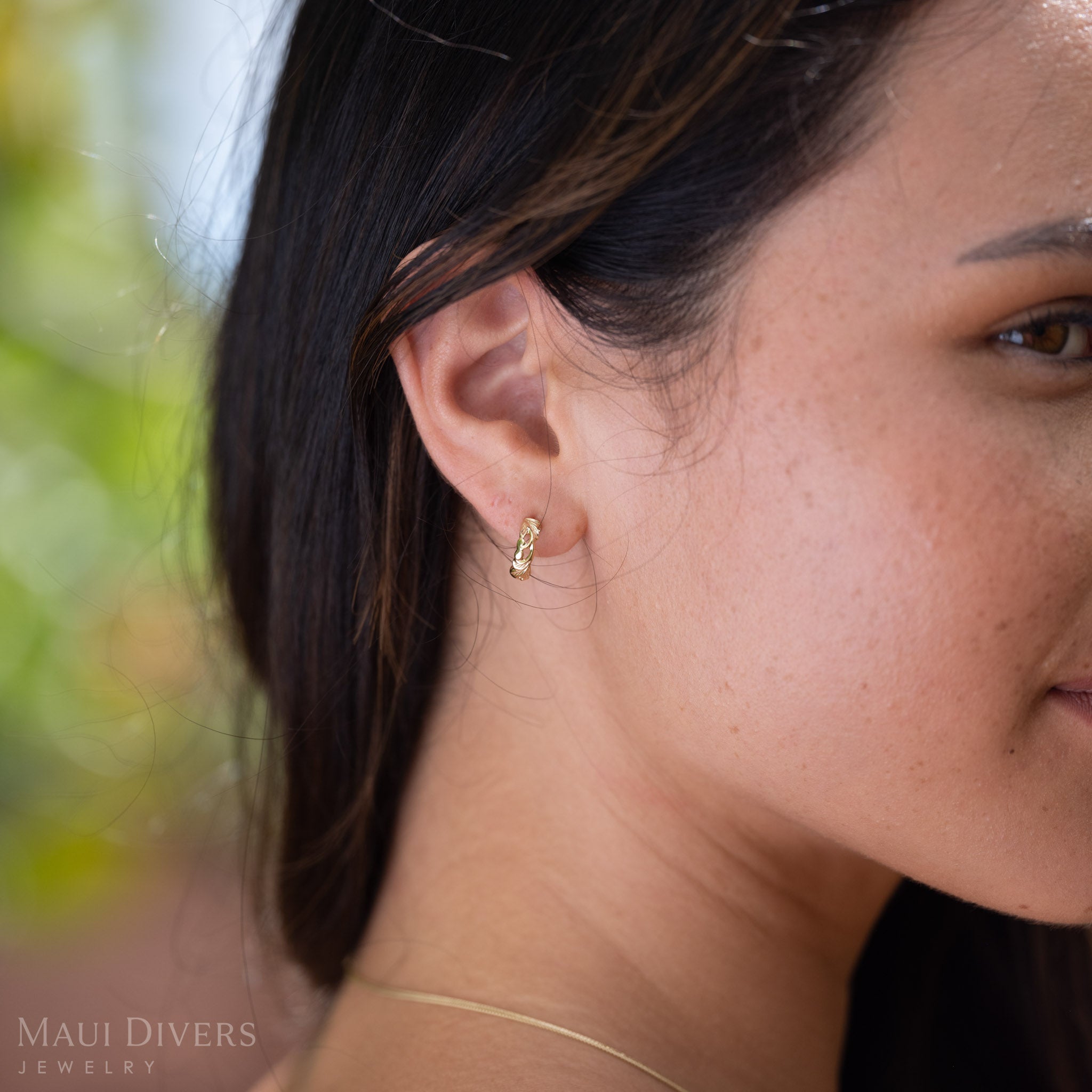 Side profile of woman wearing Hawaiian Heirloom Old English Scroll Earrings in 14k yellow gold on her ear