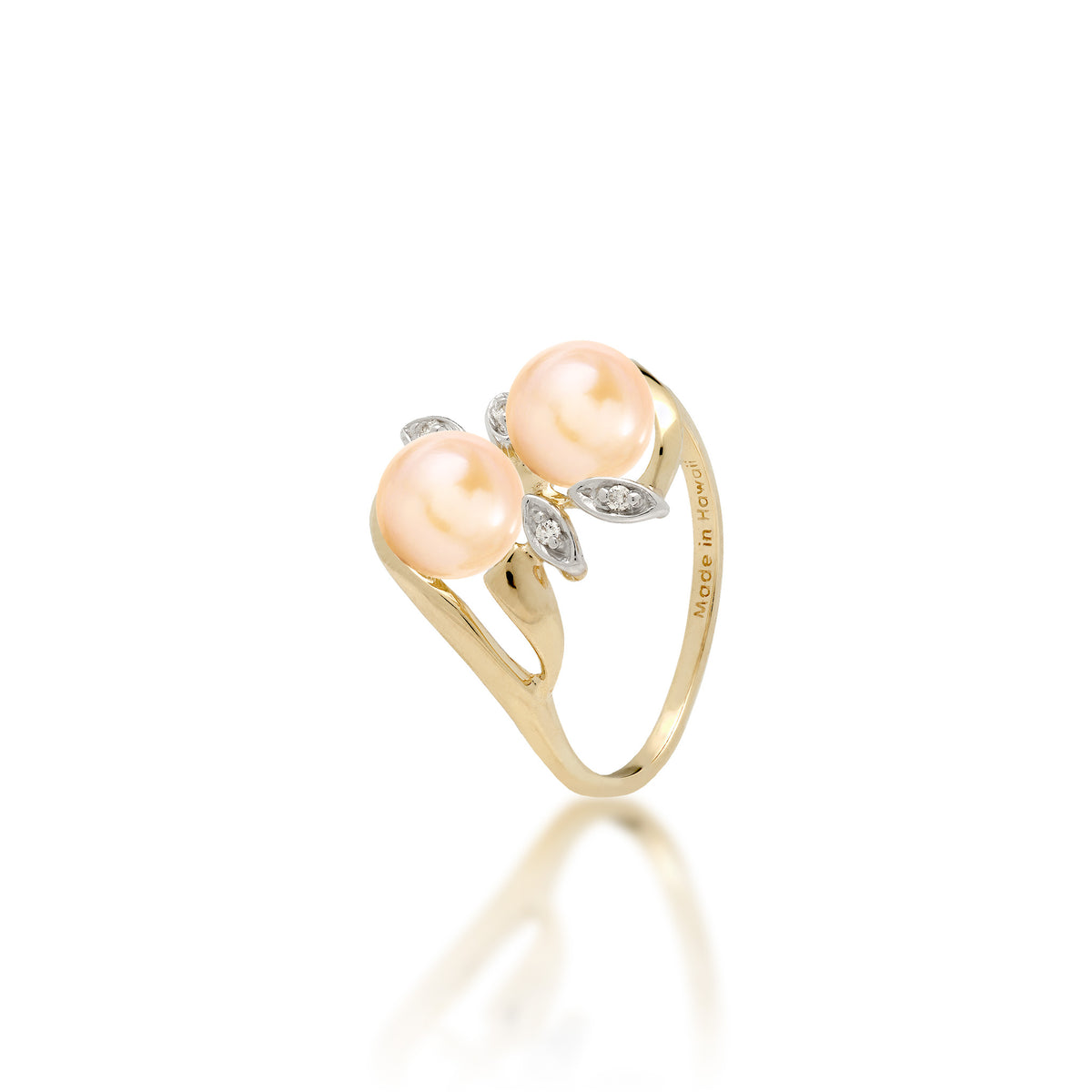 A 14k yellow gold ring with two peach freshwater pearls and two diamond accent maile leaves on each side, shown on white background
