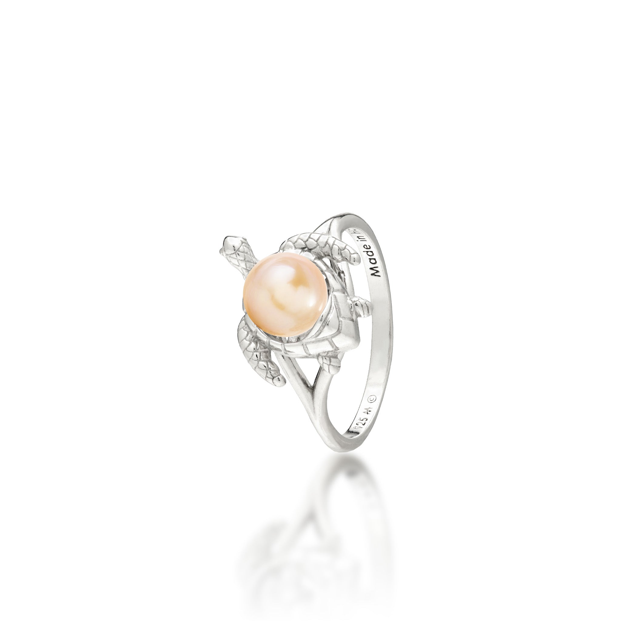 A sterling silver ring featuring a central peach freshwater pearl set on a Hawaiian green sea turtle's back, on a white background with a soft reflection.