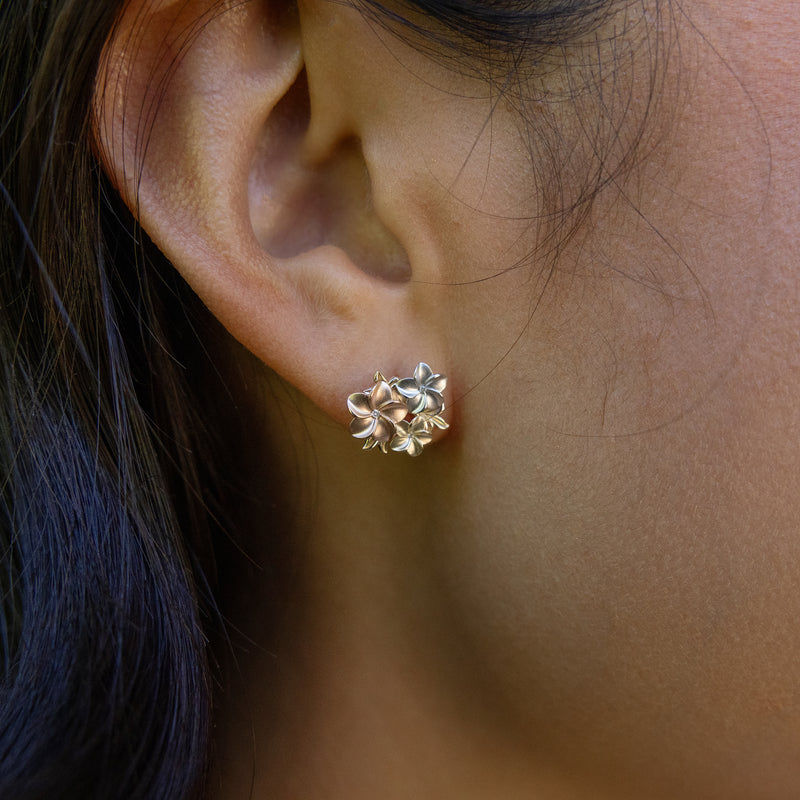 Close up of woman wearing Plumeria Earrings in Tri Color Gold with Diamonds
