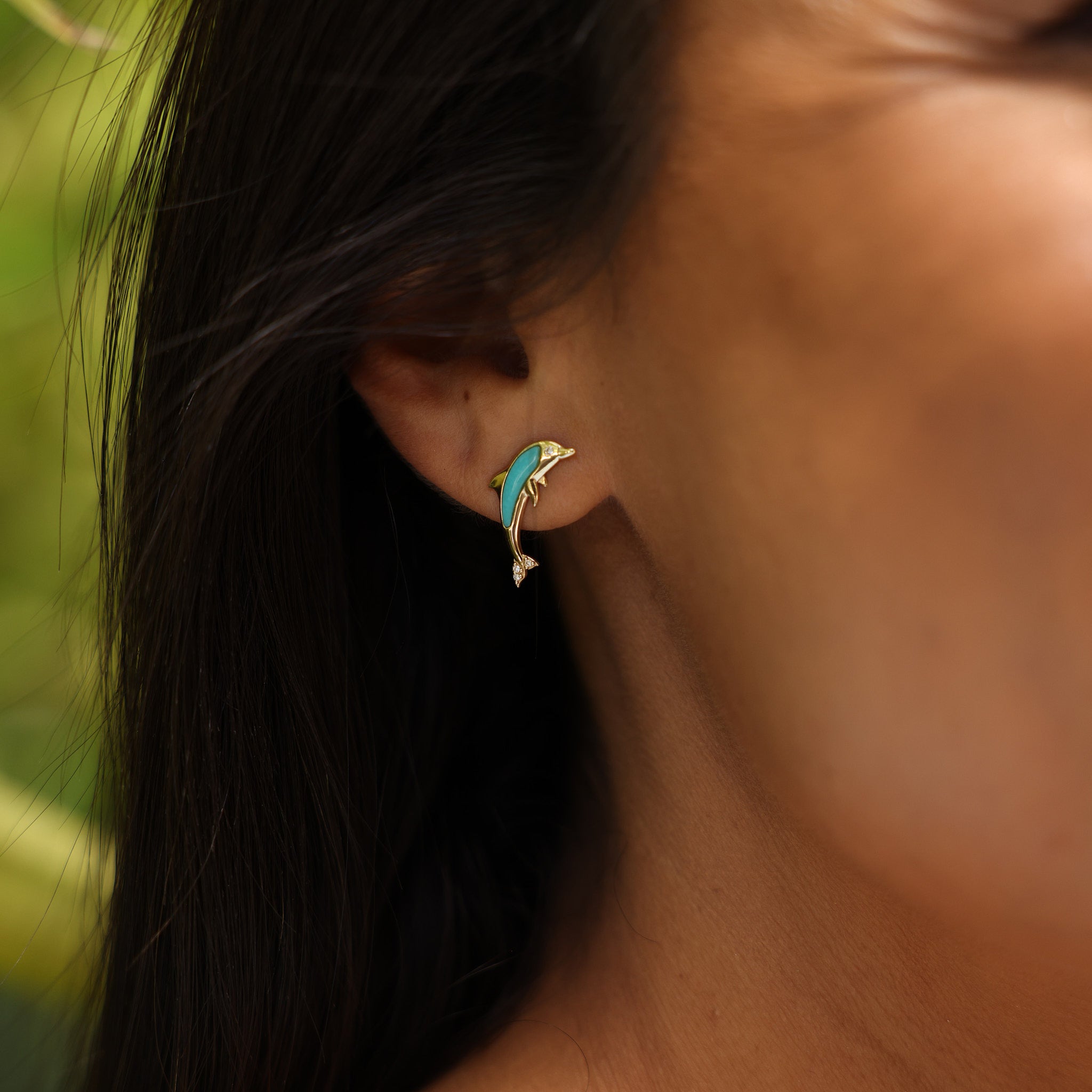 close up of woman wearing Dolphin Turquoise Earrings in Gold with Diamonds