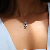 close up of Seahorse Black Coral Pendant in White Gold with Diamonds on model's neckline