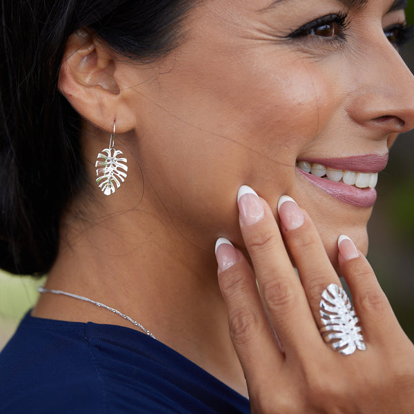 A woman's side face wearing Monstera Earrings in White Gold - 23mm and a Monstera Ring - Maui Divers Jewelry