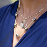 A woman wearing a 1.8mm Ovalina Chain in Gold with a pendant - Maui Divers Jewelry