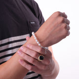 A man wearing a 8-9.5" Freshwater White Pearl Bracelet in White Gold - 6-7.5mm - Maui Divers Jewelry