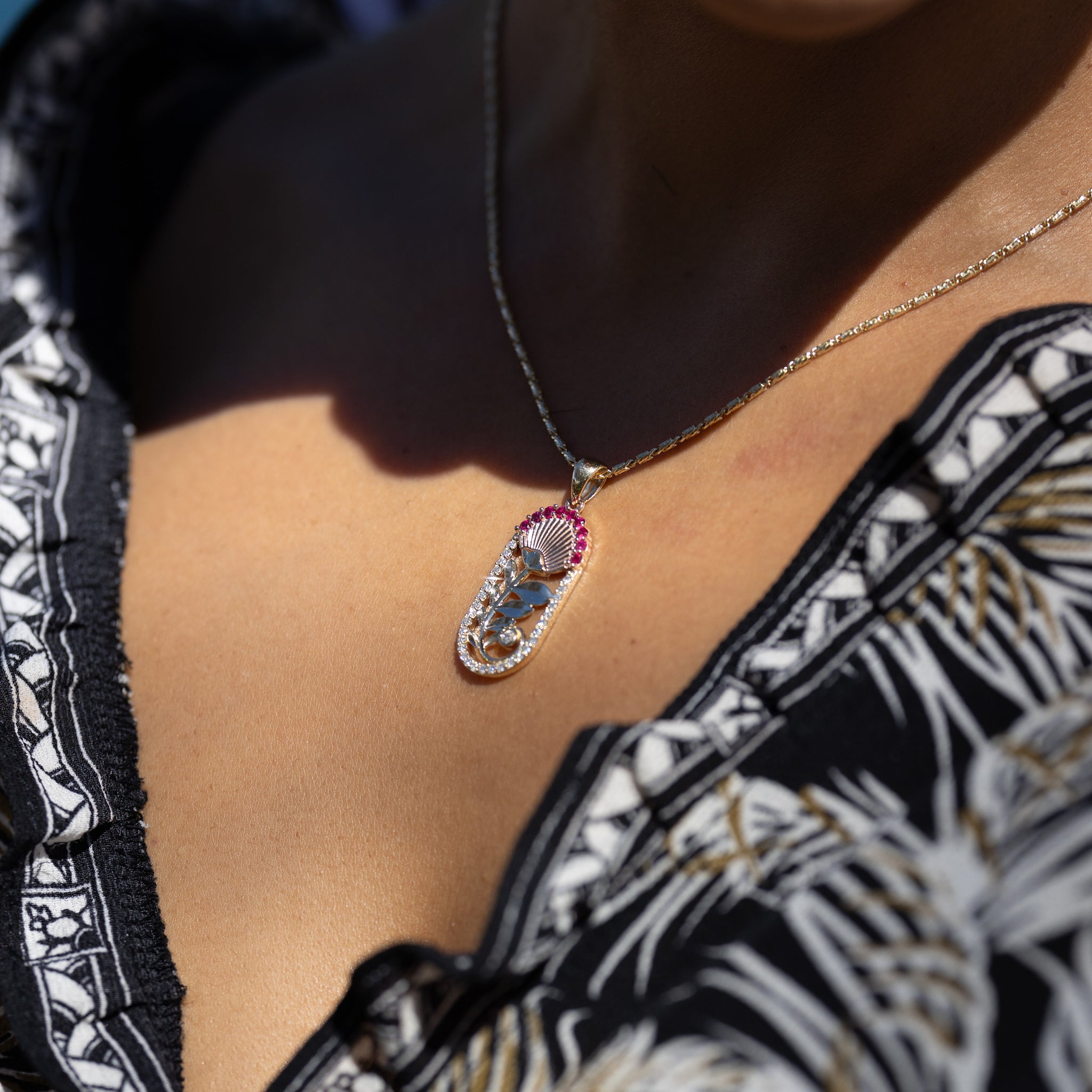 A woman wearing a Ohia Lehua Ruby Pendant in Two Tone Gold with Diamonds - 27.5mm - Maui Divers Jewelry