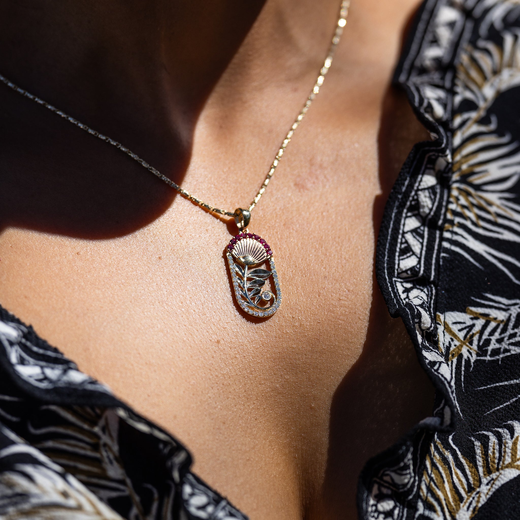 A woman wearing a Ohia Lehua Ruby Pendant in Two Tone Gold with Diamonds - 27.5mm - Maui Divers Jewelry