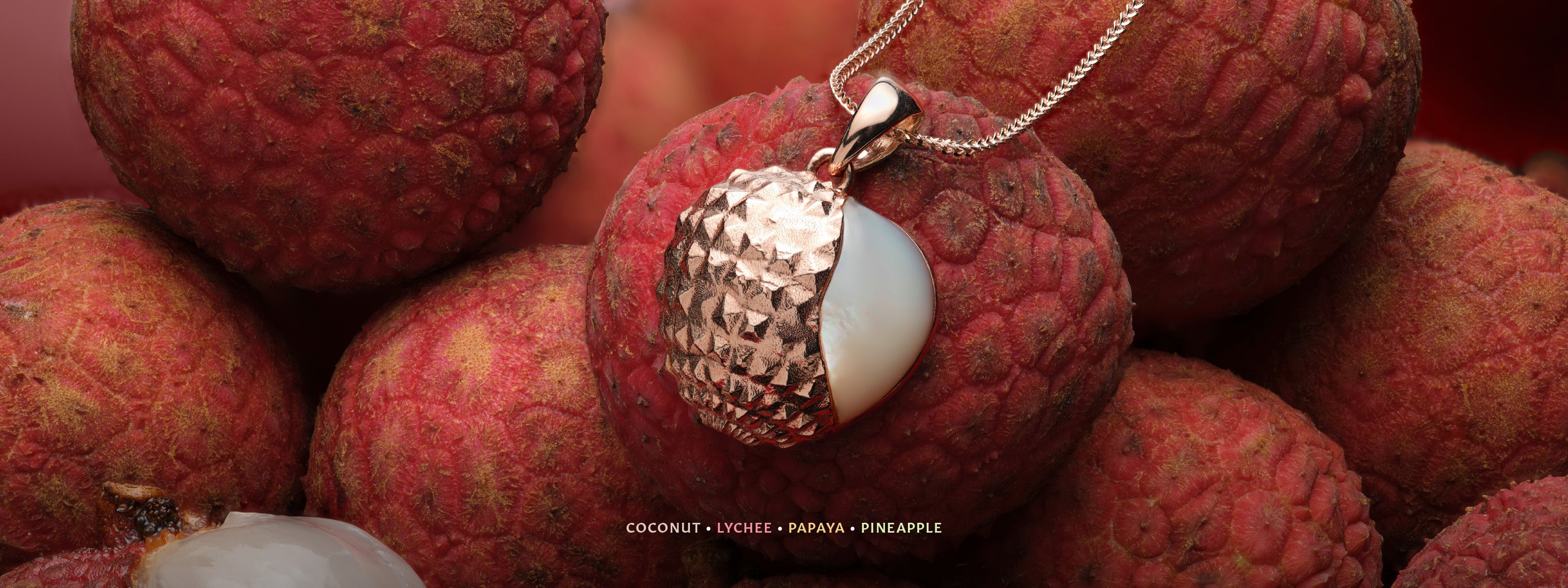 Lychee Mother of Pearl Pendant in Rose Gold on a Pile of Fresh Lychee